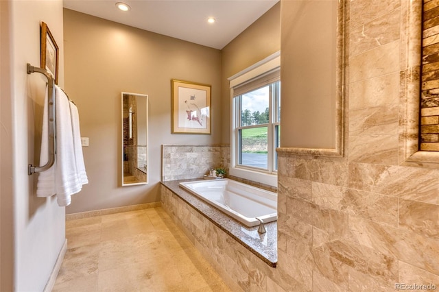 bathroom with tile patterned flooring and tiled tub