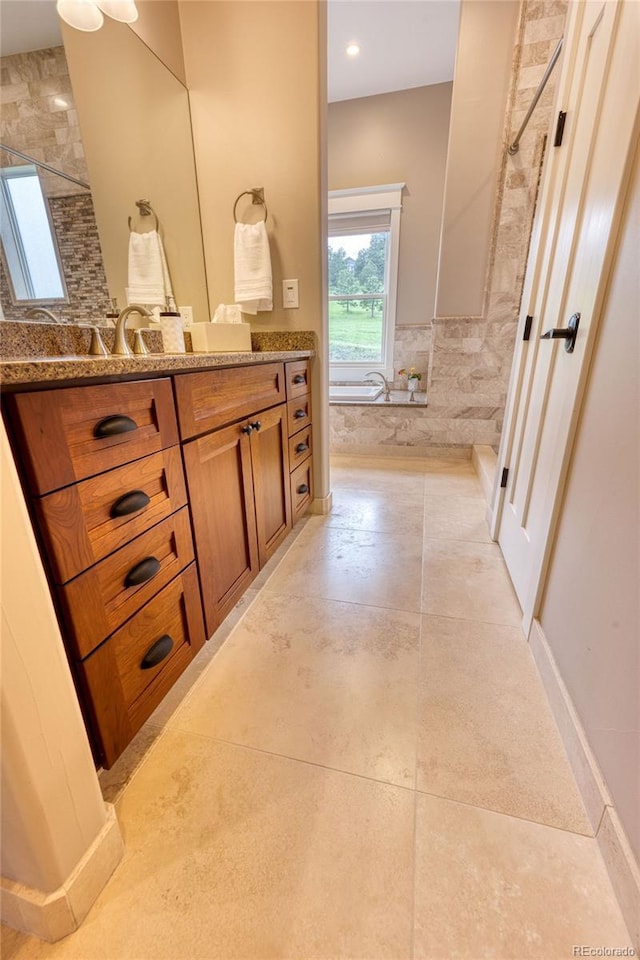 bathroom with vanity and a tile shower