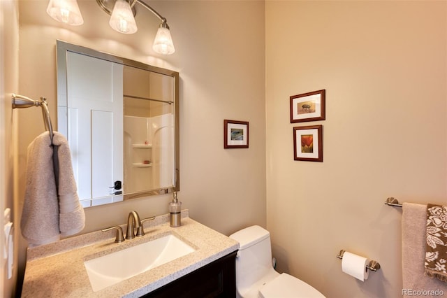 bathroom with vanity, a shower, and toilet