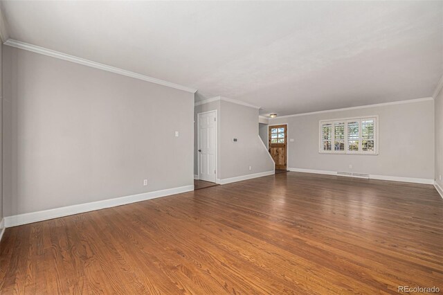 unfurnished living room featuring dark wood-type flooring and ornamental molding