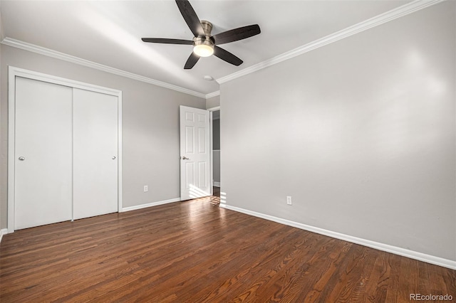 unfurnished bedroom featuring ceiling fan, ornamental molding, dark wood-type flooring, and a closet