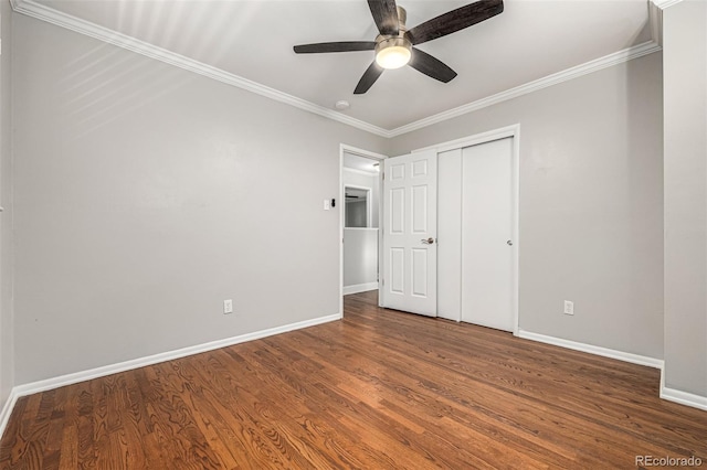 unfurnished bedroom with ceiling fan, a closet, dark wood-type flooring, and ornamental molding