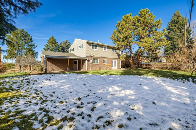 snow covered property with a lawn