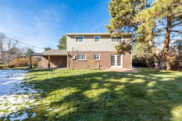 rear view of house featuring a lawn, french doors, and a patio