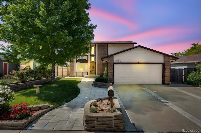 3870 S Ouray Way, Aurora, CO 80013 - view of front of home with a garage, brick siding, and driveway