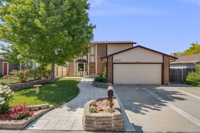 3870 S Ouray Way, Aurora, CO 80013 - view of front facade with an attached garage, brick siding, and driveway