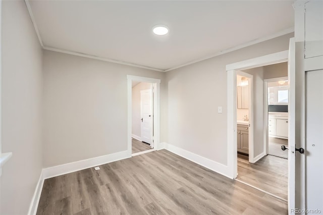 spare room featuring ornamental molding and light hardwood / wood-style flooring