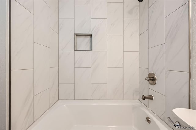 bathroom featuring tiled shower / bath