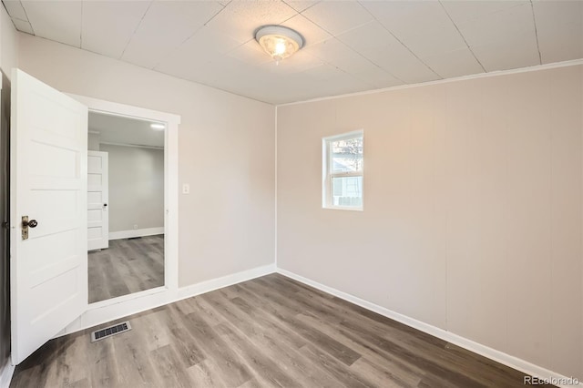 unfurnished room featuring crown molding and wood-type flooring