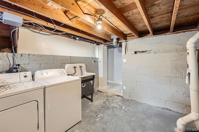 clothes washing area with separate washer and dryer and sink