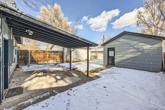 yard layered in snow featuring a carport