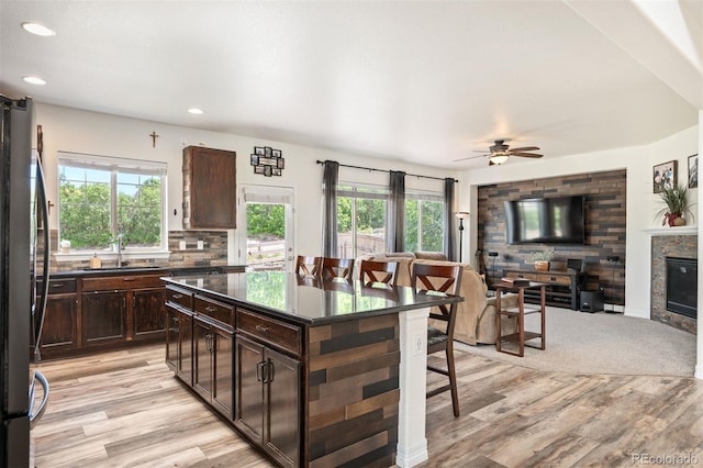 3834 Donnington Cir, Castle Rock, CO 80104 - kitchen featuring freestanding refrigerator, dark countertops, light wood finished floors, open floor plan, and plenty of natural light