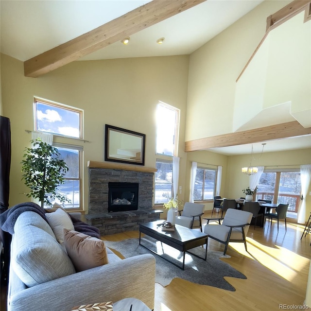 living room featuring a high ceiling, light wood-type flooring, beam ceiling, and a fireplace