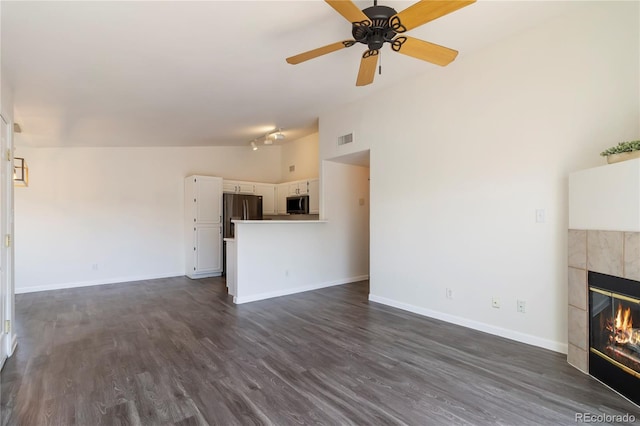 3825 Canyon Ranch Rd Unit 203, Highlands Ranch, CO 80126 - unfurnished living room with a fireplace, dark wood finished floors, a ceiling fan, and vaulted ceiling