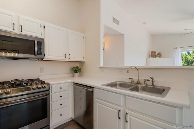 3825 Canyon Ranch Rd Unit 203, Highlands Ranch, CO 80126 - kitchen with stainless steel appliances, white cabinets, light countertops, a peninsula, and dark wood-style flooring