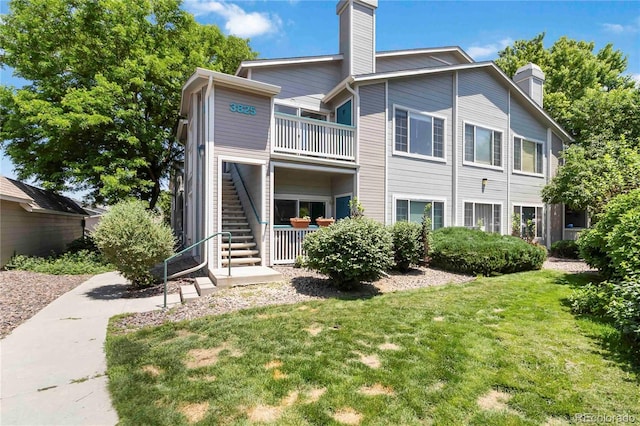 3825 Canyon Ranch Rd Unit 203, Highlands Ranch, CO 80126 - back of house featuring a chimney, stairs, and a yard