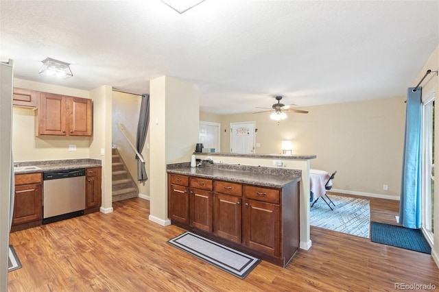 1209 Maxwell St, Colorado Springs, CO 80906 - kitchen with dishwasher, a peninsula, light wood-style floors, dark countertops, and a ceiling fan