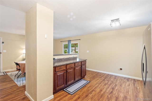 1209 Maxwell St, Colorado Springs, CO 80906 - kitchen with light wood-style flooring, dark countertops, and freestanding refrigerator