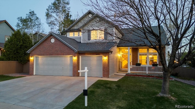 traditional-style house with covered porch, brick siding, fence, a front lawn, and concrete driveway