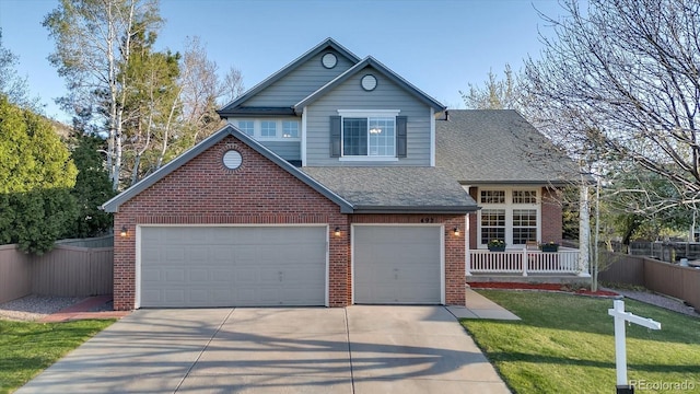 traditional-style house featuring fence, a shingled roof, concrete driveway, and brick siding