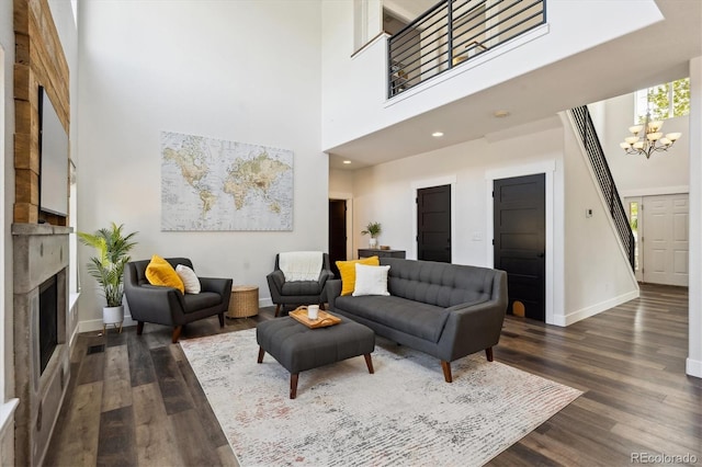 4815 Lucille Ct, Loveland, CO 80537 - living area with dark wood finished floors, a chandelier, baseboards, a fireplace, and a high ceiling