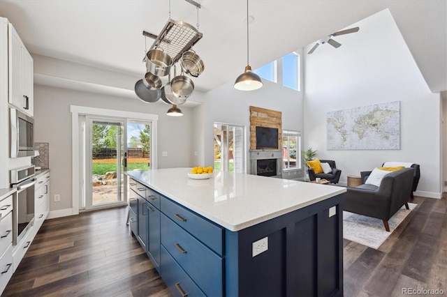 4815 Lucille Ct, Loveland, CO 80537 - kitchen featuring blue cabinets, healthy amount of natural light, white cabinets, and light countertops