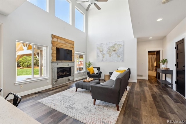 4815 Lucille Ct, Loveland, CO 80537 - living room featuring a glass covered fireplace, a towering ceiling, dark wood-style floors, ceiling fan, and recessed lighting