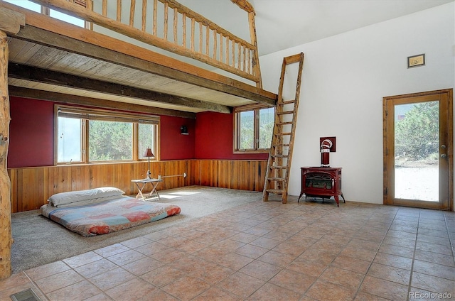 16715 Shadow Ln, Nathrop, CO 81236 - living area with a wood stove, wood walls, wainscoting, beam ceiling, and a high ceiling