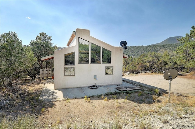 16715 Shadow Ln, Nathrop, CO 81236 - view of side of home featuring stucco siding and a wooded view
