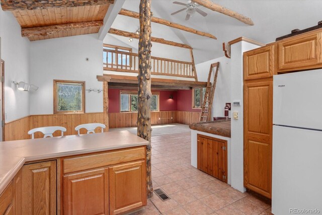 16715 Shadow Ln, Nathrop, CO 81236 - kitchen featuring freestanding refrigerator, wainscoting, wood walls, high vaulted ceiling, and ceiling fan