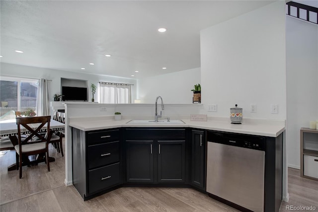 kitchen featuring dishwasher, sink, light hardwood / wood-style floors, and kitchen peninsula