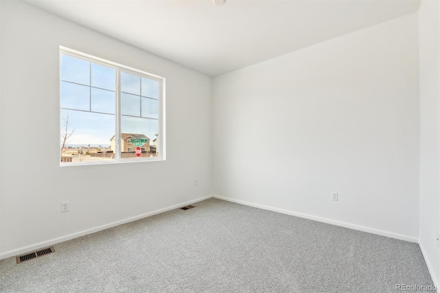 carpeted spare room with visible vents and baseboards