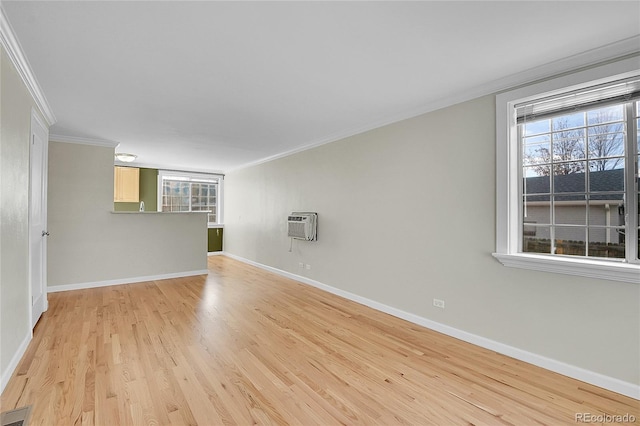 spare room featuring an AC wall unit, crown molding, and light hardwood / wood-style floors