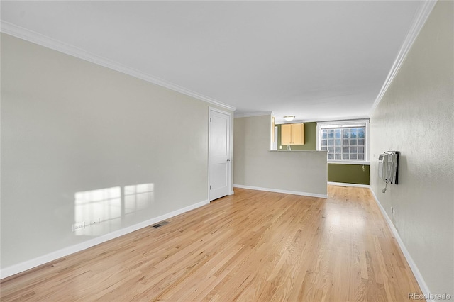 spare room with light hardwood / wood-style floors, crown molding, and heating unit