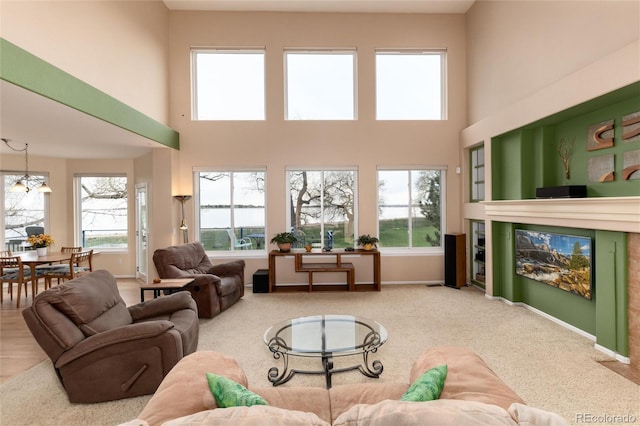4814 S Upham Ct, Littleton, CO 80123 - carpeted living area with plenty of natural light, a high ceiling, and a glass covered fireplace