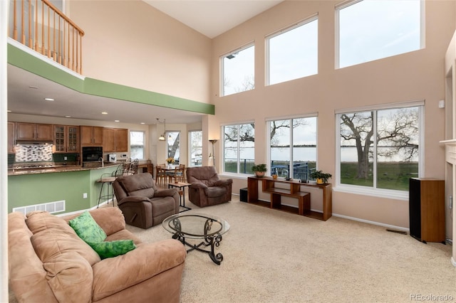 4814 S Upham Ct, Littleton, CO 80123 - living room with healthy amount of natural light, a towering ceiling, light colored carpet, and recessed lighting