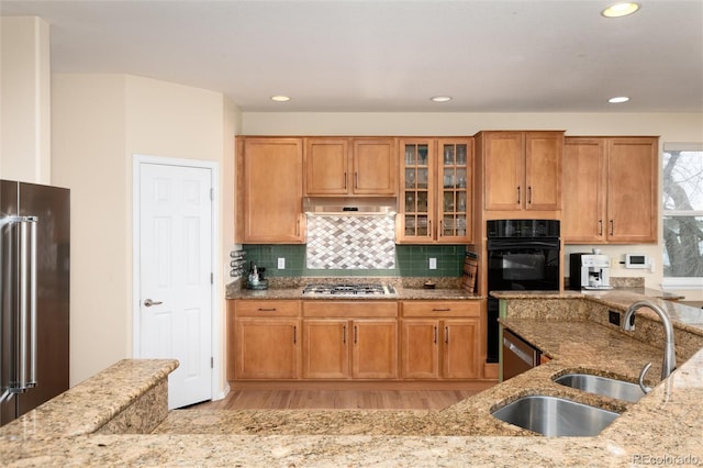 4814 S Upham Ct, Littleton, CO 80123 - kitchen with appliances with stainless steel finishes, light stone countertops, glass insert cabinets, light wood finished floors, and recessed lighting