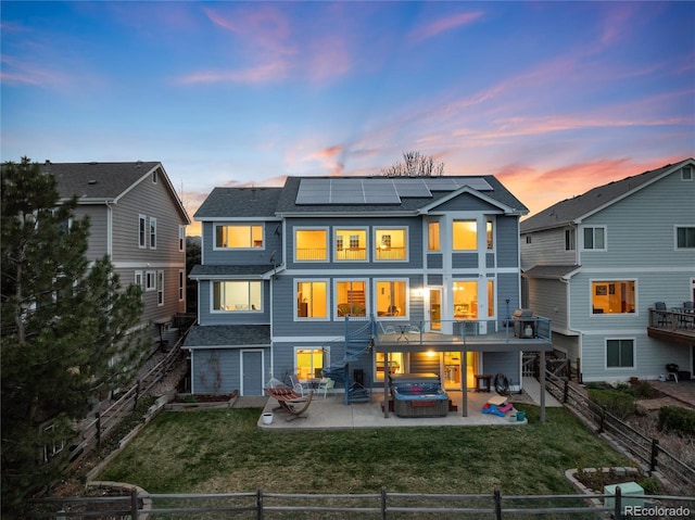 4814 S Upham Ct, Littleton, CO 80123 - rear view of property with a jacuzzi, a patio area, roof mounted solar panels, and a fenced backyard