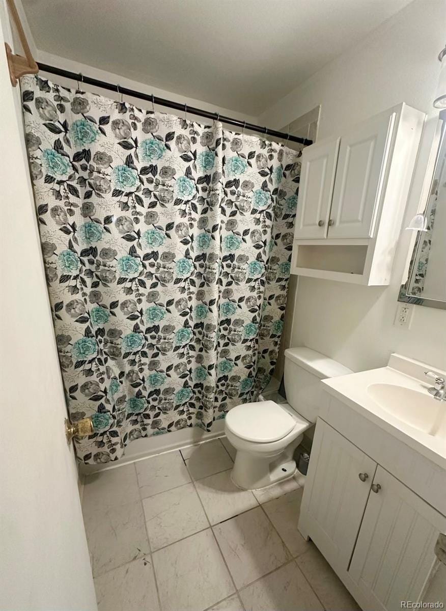 bathroom featuring tile patterned flooring, vanity, and toilet