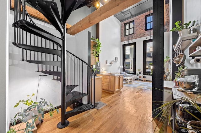 foyer featuring light wood-style floors, stairway, and a towering ceiling