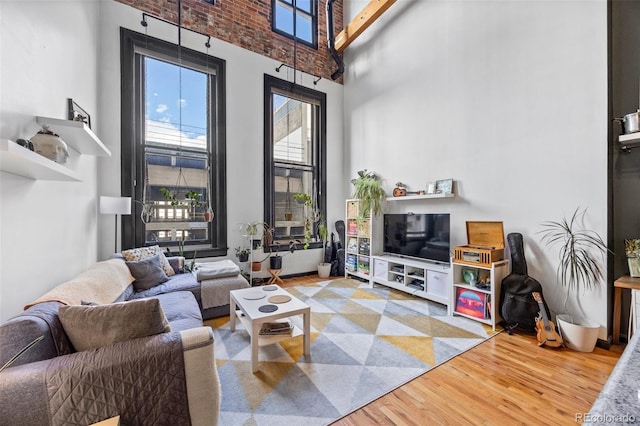 living area with wood finished floors and a high ceiling