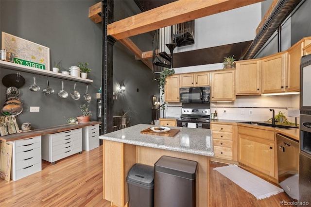kitchen with electric range, black microwave, light brown cabinets, light wood-style floors, and a sink