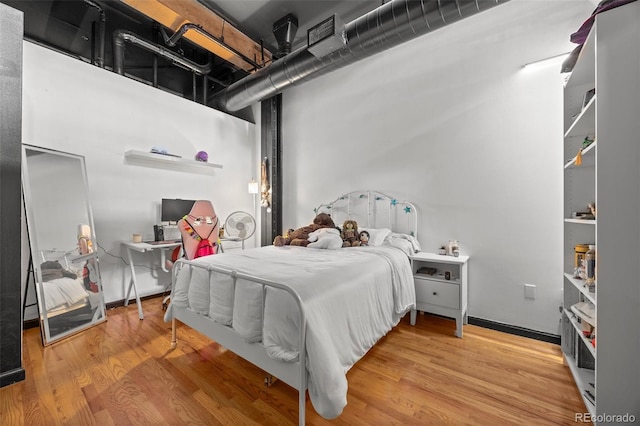 bedroom with baseboards and wood finished floors
