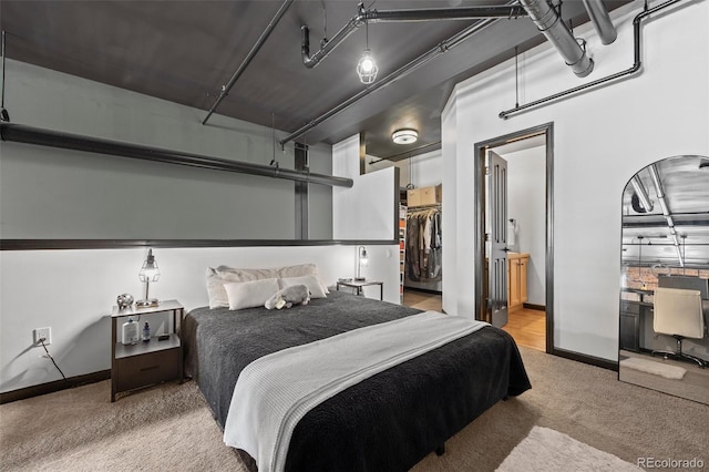 bedroom with carpet flooring, a walk in closet, baseboards, refrigerator, and a closet