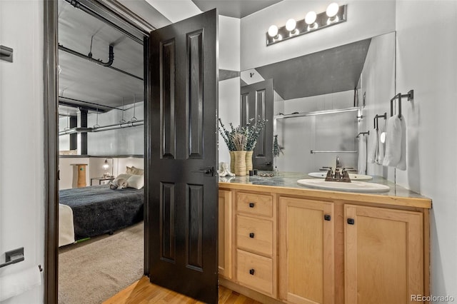 ensuite bathroom featuring vanity, an enclosed shower, wood finished floors, and ensuite bathroom