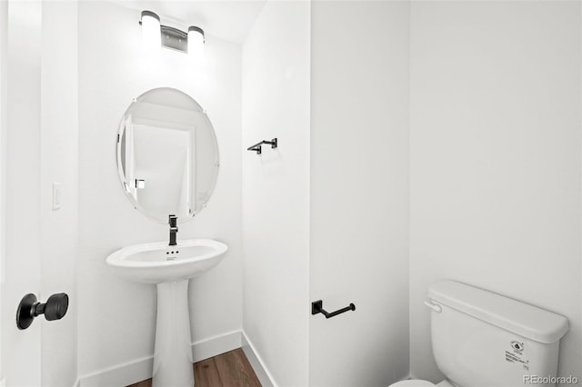 bathroom with hardwood / wood-style flooring and toilet