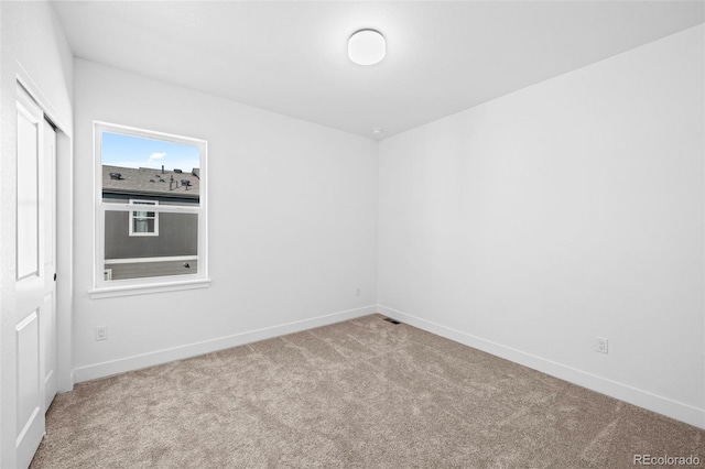 unfurnished room featuring light colored carpet