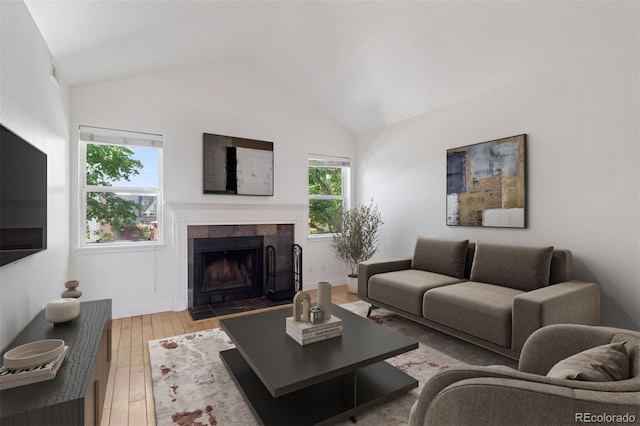 11 W Ellsworth Ave Unit 22, Denver, CO 80223 - living area featuring vaulted ceiling, light wood-style floors, a tiled fireplace, and baseboards