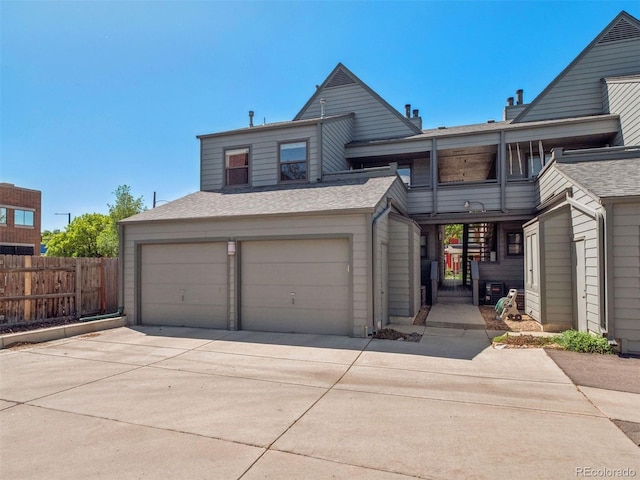 11 W Ellsworth Ave Unit 22, Denver, CO 80223 - view of front of property with an attached garage, driveway, and a shingled roof