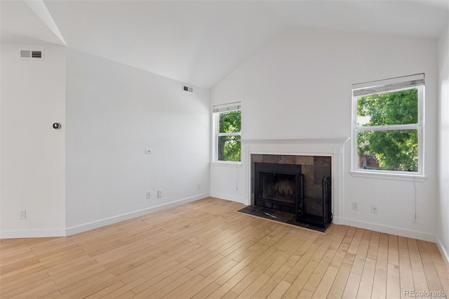 11 W Ellsworth Ave Unit 22, Denver, CO 80223 - unfurnished living room with wood finished floors, a tile fireplace, baseboards, and high vaulted ceiling